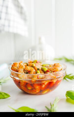 Frischer Salat mit Garnelen und Edamame Sojabohnen in einer Schüssel auf einem weißen Tisch. Stockfoto