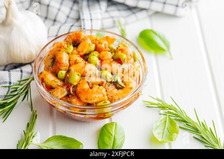 Frischer Salat mit Garnelen und Edamame Sojabohnen in einer Schüssel auf einem weißen Tisch. Stockfoto