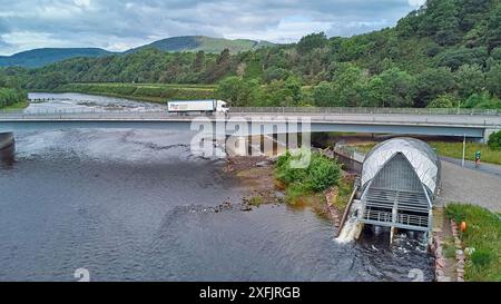 Hydro Ness Wasserkraftwerk am Fluss Ness Schottland Blick auf die großen Flusshügel und die A8082 Holm Mills Bridge Stockfoto