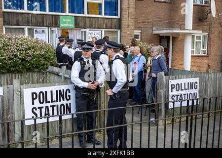 London, Großbritannien. 4. Juli 2024. Die Polizei wartet auf den Ausgang von Sir Keir Starmer, dem Vorsitzenden der Labour Party, und seiner Frau Victoria, nachdem sie am Morgen der Parlamentswahlen in einer Wahlstation in Kentish Town im Norden Londons ihre Stimmen abgegeben haben. Die letzte YouGov-Umfrage projiziert einen Erdrutschsieg für Labour. Sir Keir und seine Frau sind an einem Hinterausgang abgereist. Quelle: Stephen Chung / Alamy Live News Stockfoto