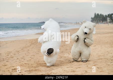 Animateure, die als Eisbären verkleidet sind, unterhalten die Leute am Strand Stockfoto