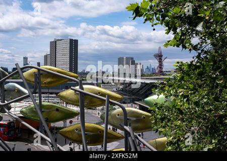 Blick auf das Carpenters Estate und den Olympic Park von der Installation Shoal von Studio Egret West, die am 1. Juli 2024 in London, Großbritannien, Menschen für die Olympischen Spiele 2012 vor dem alten Einkaufszentrum Stratford Centre in der regenerierten Stratford City willkommen heißen soll. Das Carpenters Estate in Stratford liegt ganz in der Nähe des Queen Elizabeth Olympic Park. Das Anwesen besteht aus flachen Sozialwohnungen und drei Turmblöcken. Das Anwesen wurde fortwährend für Abriss und Sanierung vorgesehen. Stockfoto