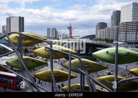 Blick auf das Carpenters Estate und den Olympic Park von der Installation Shoal von Studio Egret West, die am 1. Juli 2024 in London, Großbritannien, Menschen für die Olympischen Spiele 2012 vor dem alten Einkaufszentrum Stratford Centre in der regenerierten Stratford City willkommen heißen soll. Das Carpenters Estate in Stratford liegt ganz in der Nähe des Queen Elizabeth Olympic Park. Das Anwesen besteht aus flachen Sozialwohnungen und drei Turmblöcken. Das Anwesen wurde fortwährend für Abriss und Sanierung vorgesehen. Stockfoto