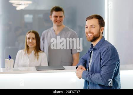 Dankbarer Patient. Mann steht an der Rezeption der Zahnklinik und ist sehr erfreut über die Behandlung Stockfoto