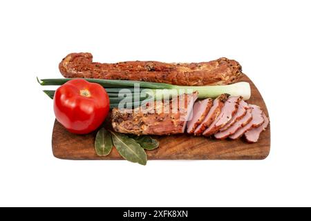 Schweinefleischfilet Pastrami, geräuchert und gewürzt, mit dünnen Scheiben, Tomaten und Frühlingszwiebeln, auf einem hölzernen Schneidebrett Stockfoto