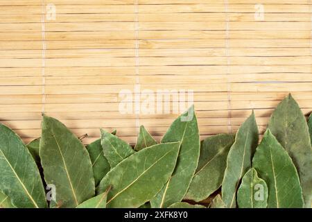 Bay hinterlässt Stapelrahmen auf Bambus-Rollenmatte Hintergrund Stockfoto
