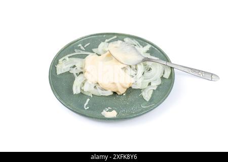 In Scheiben geschnittene Zwiebeln mit Mayonnaise auf einem Teller isoliert auf weiß Stockfoto