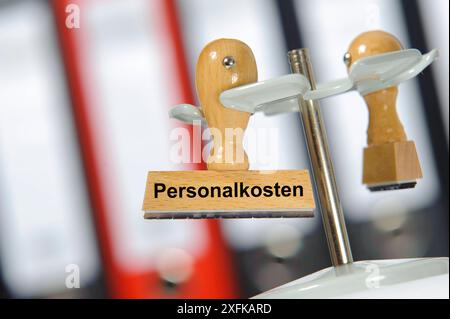 Personalkosten in einem Büro mit Aktenordner hängt ein Holzstempel mit dem Aufdruck: Personalkosten *** Personalkosten Eine Holzmarke mit den Worten Stockfoto