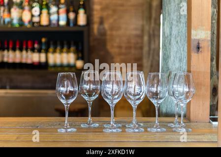 Eine Reihe Weingläser stehen auf einer Bar. Die Gläser sind alle klar und leer Stockfoto