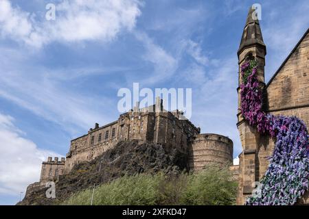 Das Edinburgh Castle am Castle Rock und blühende Blumen am alten Turm in Edinburgh, Schottland, Großbritannien. Stockfoto