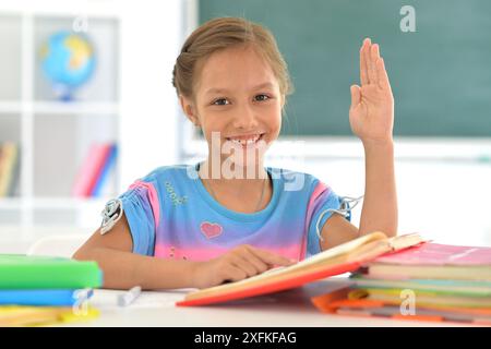 Porträt eines Mädchens, das mit Büchern im Klassenzimmer gesteckt wurde Stockfoto