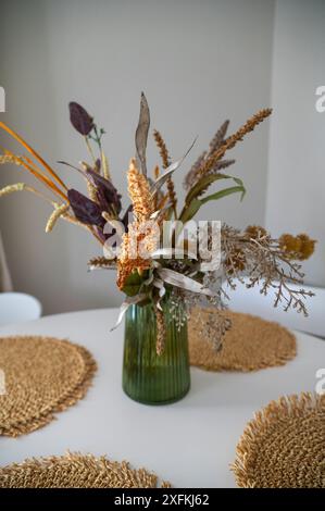 Dekorative Vase mit getrockneten Blumen auf dem Tisch. Stockfoto