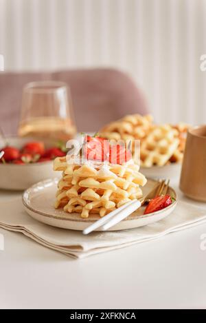 Belgische Waffeln mit Erdbeeren und Puderzucker auf weißem Tisch. Sommer-Food-Konzept. Weichzeichner Stockfoto