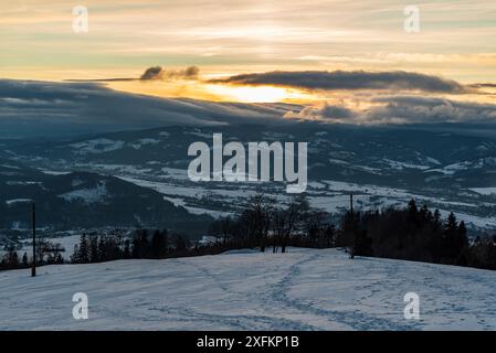 Sonnenuntergang mit Wolken von Bahenec im Winter Slezske Beskydy Berge in Tschechien Stockfoto