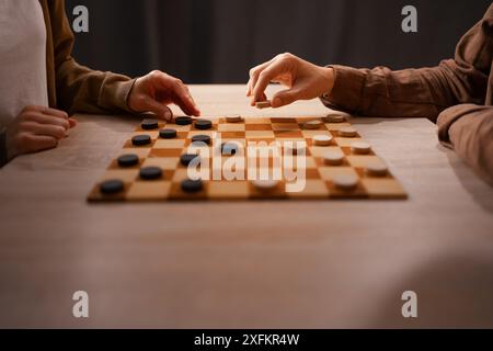 Zwei Freunde spielen zu Hause Checkers, genießen Freizeit und gemütliche Atmosphäre Stockfoto