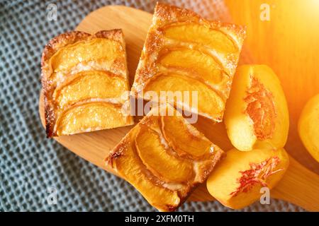 Ein Dessert aus geschnittenen Pfirsichen ist auf einem hölzernen Schneidebrett. Das Dessert ist mit Zucker bedeckt und sieht köstlich aus. Stockfoto