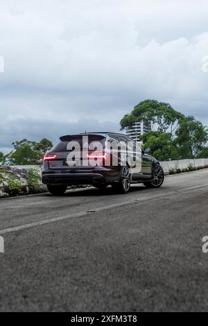 Schwarzer Audi RS6 Rückblick in leerer Straße, bewölkter Tag, luxuriöses Familienauto, High Resolution Stockfoto