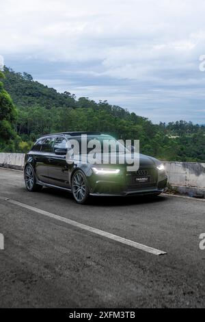 Schwarzer Audi RS6-Vorderansicht, grüner Berghintergrund, Luxusauto an mutigen Tagen, High Resolution Stockfoto
