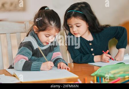 Kinder, Schreiben und Hausaufgaben auf dem Tisch, zu Hause und Kopie der Schwester für Antwort, Mathematik und Schüler der Vorschule. Haus, Bildung und Wissen für Stockfoto