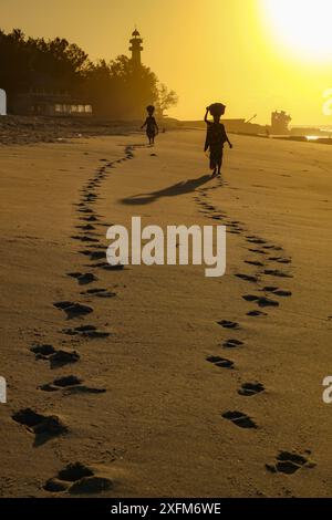 Fußabdrücke im Sand von Frauen, die Garnelenkörbe am Strand, Beira, Mosambik, tragen. Juni 2011 Stockfoto