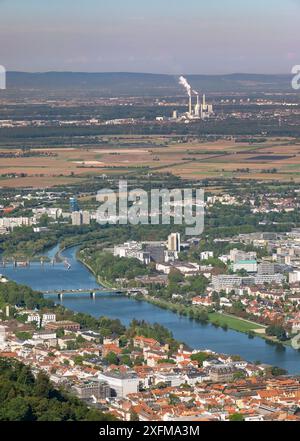 Eine Stadt mit einem Fluss und einem großen Kraftwerk im Hintergrund. Die Stadt ist voller Aktivitäten und das Kraftwerk ist ein wichtiger Punkt Stockfoto