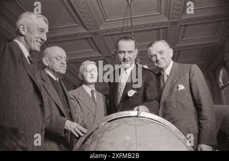 Konteradmiral Hyman G. Rickover (dritter von links), der hinter einem Globus stand, bei Anhörungen des Senatsvorsorge-Unterausschusses des Committee on Armed Services mit Senator Leverett Saltonstall (erster von links), Senator Ralph Flanders aus Vermont (zweiter von links), Vorsitzender Lyndon B. Johnson (vierter von links) und einem weiteren Mann. 1958 Jan. Von O'Halloran, Thomas J., Fotograf Stockfoto