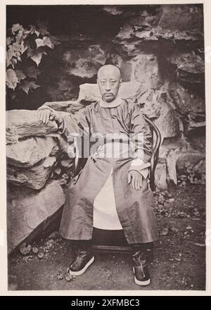 Vintage-Foto des chinesischen Prinzen Yixin (Prinz Gong oder Prinz Kung). Illustration of China, 1875 Yixin (1833–1898), besser bekannt als Prinz Kung oder Gong, war ein kaiserlicher Prinz des Aisin Gioro-Clans und ein wichtiger Staatsmann der mandschu-geführten Qing-Dynastie in China. Er war von 1861 bis 1865 Regente des Reiches und hatte auch in anderen Zeiten großen Einfluss. Prinz Kung, sechster Sohn des Kaisers Tao Kwang, der von 1820 bis 1850 regierte. Hi ist ein jüngerer Bruder des verstorbenen Kaisers Hien-foong und somit Onkel des regierenden Kaisers Tung-che. Er hält mehrere hohe Civi Stockfoto