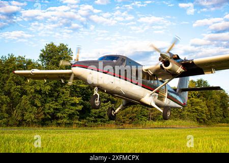 Kleiner Jet, der auf dem ländlichen grünen Landebahnfeld aus nächster Nähe startet Stockfoto