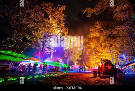 Farbenfrohe nächtliche Zeltfest mit beleuchteten Bäumen und Lichttabletts Stockfoto