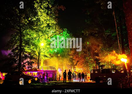 Farbenfrohe nächtliche Zeltfest mit beleuchteten Bäumen und Lichttabletts Stockfoto