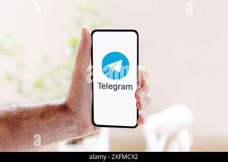 Mann, der ein Handy hält, das die Telegramm-App auf dem Bildschirm anzeigt. ROSARIO, ARGENTINIEN - 03. JULI 2024. Stockfoto