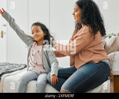 Morgens, Mutter und Mädchen zu Hause mit Haarbürste für die Pflege Routine, Unterstützung oder Wellness im Schlafzimmer. Eltern, Liebe und alleinerziehende Mutter machen sich bereit Stockfoto