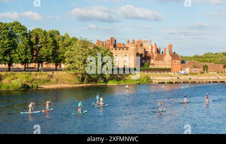 Stand-up-Paddelboarder auf der Themse im Hampton Court Palace in der Nähe von London Stockfoto