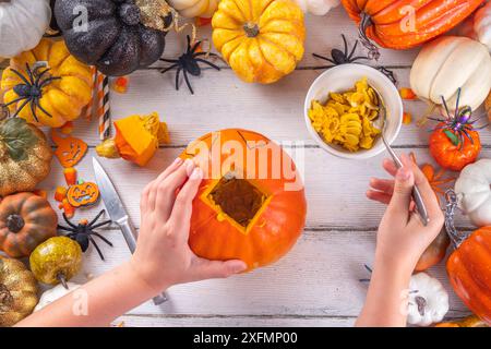 Halloween-Vorbereitung mit schnitzendem Kürbis Jack Lantern. Frauen, Frauen und Kinder Hände im Rahmen, dekorieren, zeichnen und schnitzen gruselige Hallowe Stockfoto