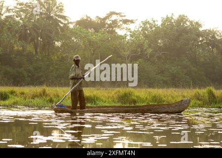 Fischer stehen in ausgegrabenem Kanu, Lagunen des Naturparks Cufada (Lagoas de Cufada), Guinea-Bissau. Februar 2015 Stockfoto