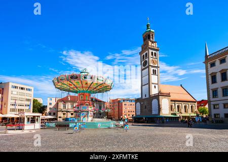 Augsburg - 06. Juli 2021: Kettenkarussell und Perlachturm-Turm, ein Glockenturm vor der Kirche St. Peter am Perlach. Augsburg ist ein Zitat Stockfoto