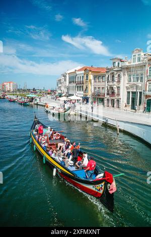 Die malerischen Boote gleiten entlang der malerischen Kanäle von Aveiro, oft auch als „Venedig von Portugal“ bezeichnet, und zeigen den einzigartigen Charme und das maritime Erbe der Stadt. Stockfoto