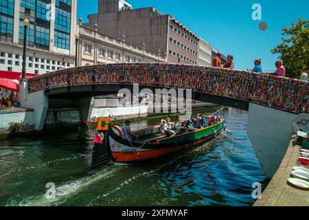 Die malerischen Boote gleiten entlang der malerischen Kanäle von Aveiro, oft auch als „Venedig von Portugal“ bezeichnet, und zeigen den einzigartigen Charme und das maritime Erbe der Stadt. Stockfoto