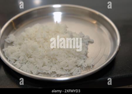 Ein Nahbild von gekochtem weißem Reis, serviert auf einer glänzenden Edelstahlplatte, bereit zum Verzehr. Stockfoto