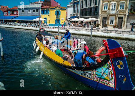 Die malerischen Boote gleiten entlang der malerischen Kanäle von Aveiro, oft auch als „Venedig von Portugal“ bezeichnet, und zeigen den einzigartigen Charme und das maritime Erbe der Stadt. Stockfoto