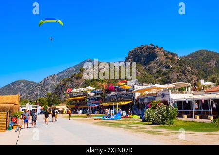 Oludeniz, Türkei - 13. Juli 2022: Fliegender Gleitschirmflieger im Zentrum von Oludeniz oder am Strand der Blauen Lagune im Bezirk Fethiye der Provinz Mugla, Türkei. Stockfoto