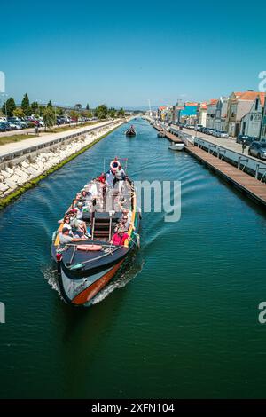 Die malerischen Boote gleiten entlang der malerischen Kanäle von Aveiro, oft auch als „Venedig von Portugal“ bezeichnet, und zeigen den einzigartigen Charme und das maritime Erbe der Stadt. Stockfoto