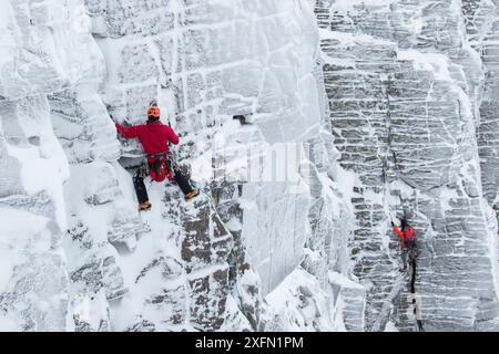 Kletterer auf vertikaler Felswand im Winter, Northern Corries, Cairngorms National Park, Schottland, Großbritannien, Dezember 2015. Stockfoto