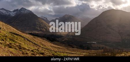 Berge mit Lichtschacht, die durch Wolken kommen, Glencoe, Schottland, Februar 2017. Stockfoto