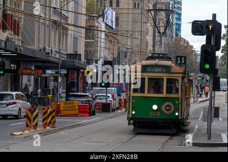 Die kostenlose Fahrt mit der grünen und gelben Straßenbahn Nr. 35, die sich der Straßenbahnhaltestelle Flinders Street in Melbourne, Victoria, Australien nähert. Die NO Stockfoto