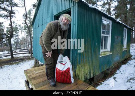 Wildhüter / Hirschstalker mit Futter für Rotwild außerhalb des Stalls, Alvie Estate, Cairngorms National Park, Schottland, Großbritannien, Juni Stockfoto