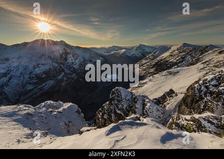 Sonnenuntergang über schneebedeckten Bergen, Blick nach Nordwesten entlang des Aonach Eagach Ridge in Richtung Glen Coe, Lochaber, Schottland, Großbritannien, November 2016 Stockfoto