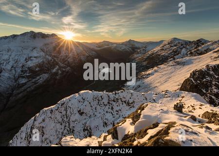 Sonnenuntergang über schneebedeckten Bergen, Blick nach Nordwesten entlang des Aonach Eagach Ridge in Richtung Glen Coe, Lochaber, Schottland, Großbritannien, November 2016 Stockfoto