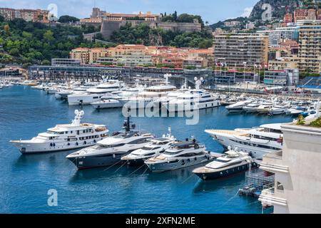 Luxusyachten liegen im Hafen von Port Hercule, mit der Altstadt und dem Fürstenpalast oben, in Monte Carlo, Monaco an der französischen Riviera, Côte d'Azur Stockfoto