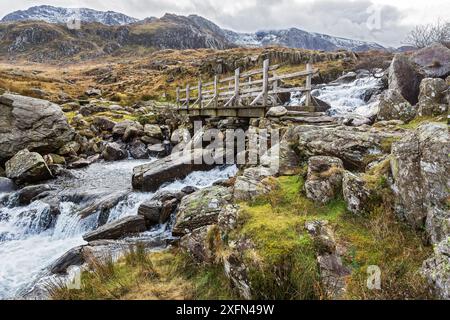 Brücke über den Wasserfall in der Nähe von Llyn Ogwen auf dem Weg nach Llyn Idwal und der Teufelsküche im Glyderau-Gebirge Snowdonia North Wales, Großbritannien, Februar. Stockfoto